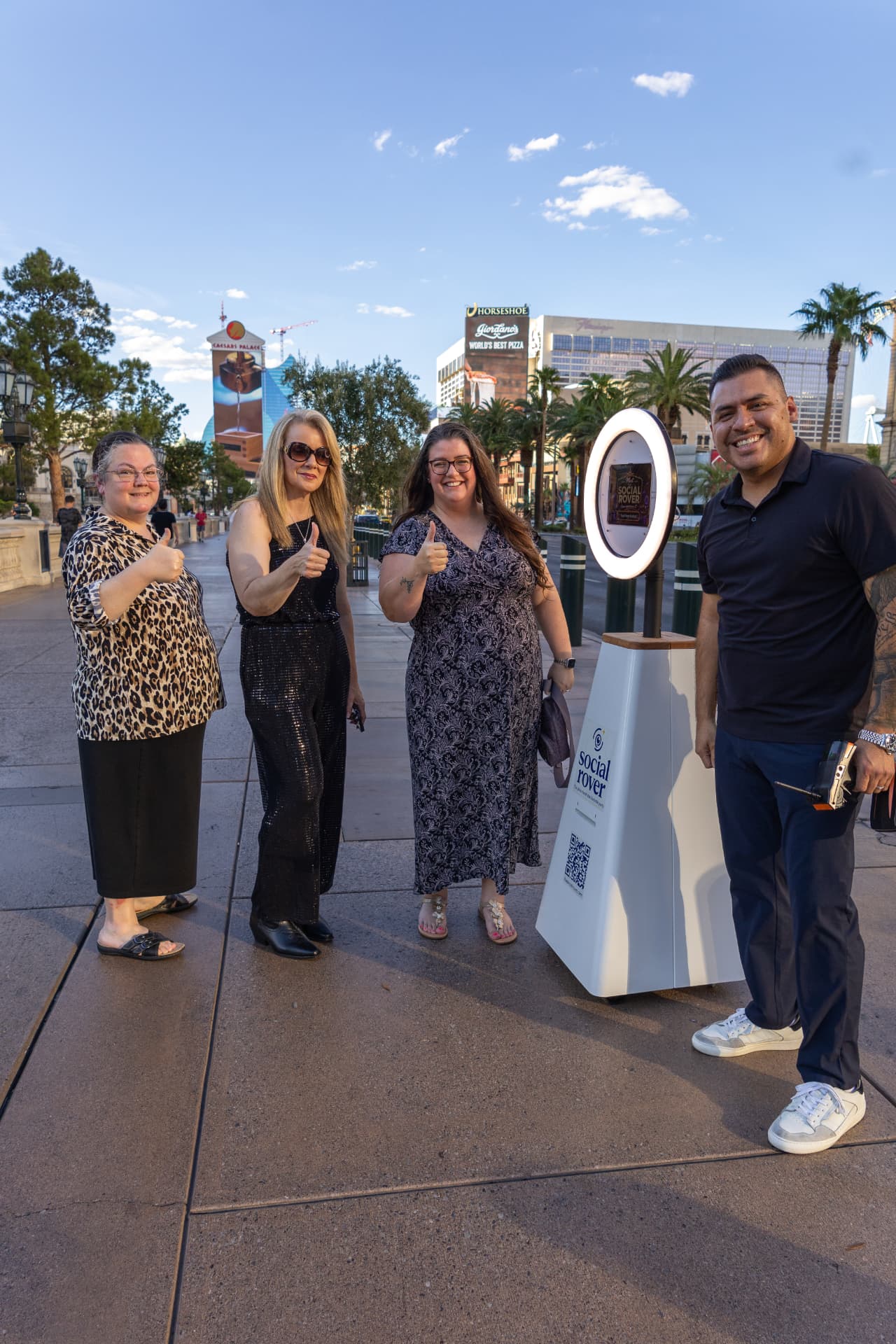 Group giving thumbs up next to The Social Rover on the Las Vegas Strip